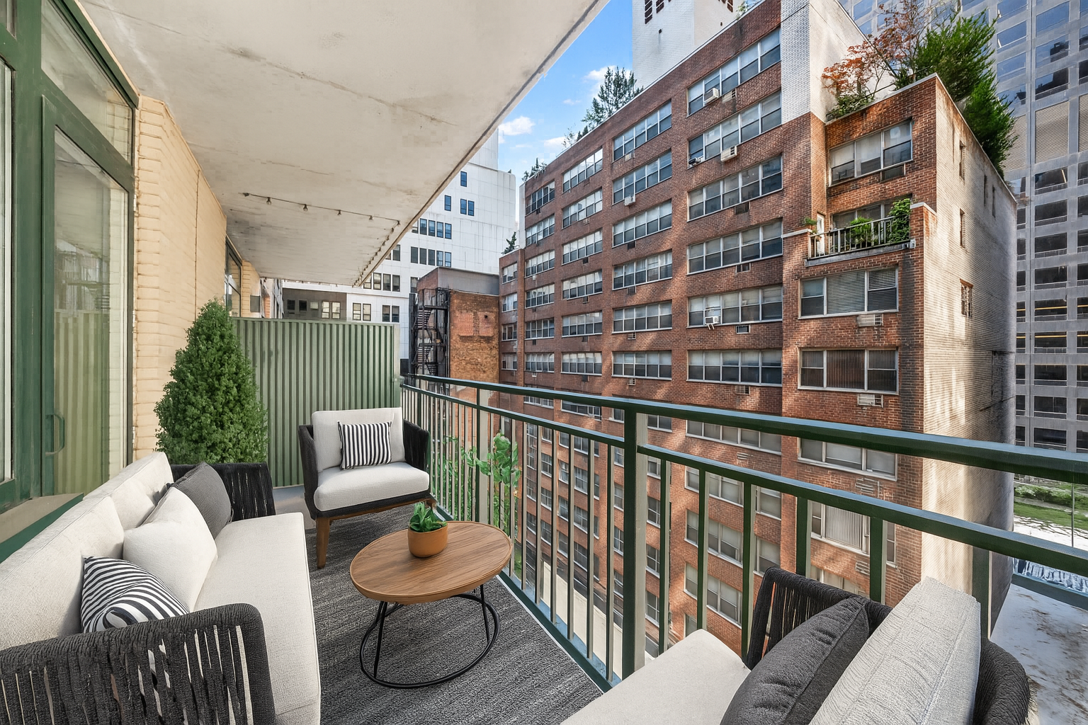 212 East 57th Street, Unit 5C Manhattan, NY 10022 - Photo 5 of 10 a balcony with couches and a potted plant on a table