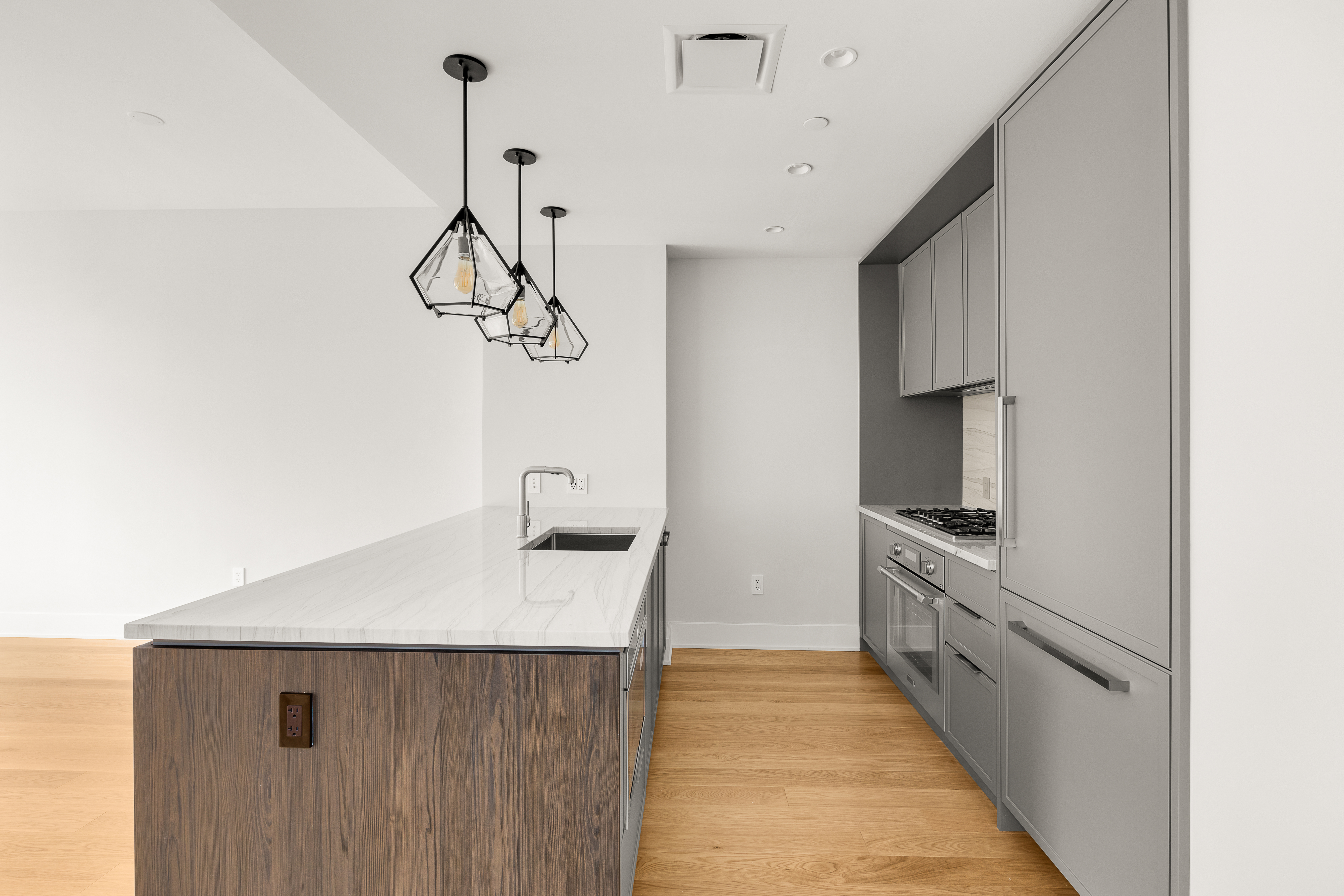 218 West 103rd Street, Unit 6B Manhattan, NY 10025 - Photo 2 of 5 a kitchen with kitchen island granite countertop a sink a counter top space and cabinets