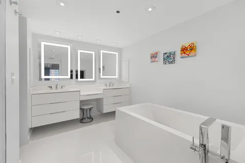 a large white kitchen with stainless steel appliances lots of counter top space