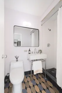 a bathroom with a sink toilet and a mirror