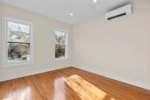 a view of a big room with wooden floor and windows