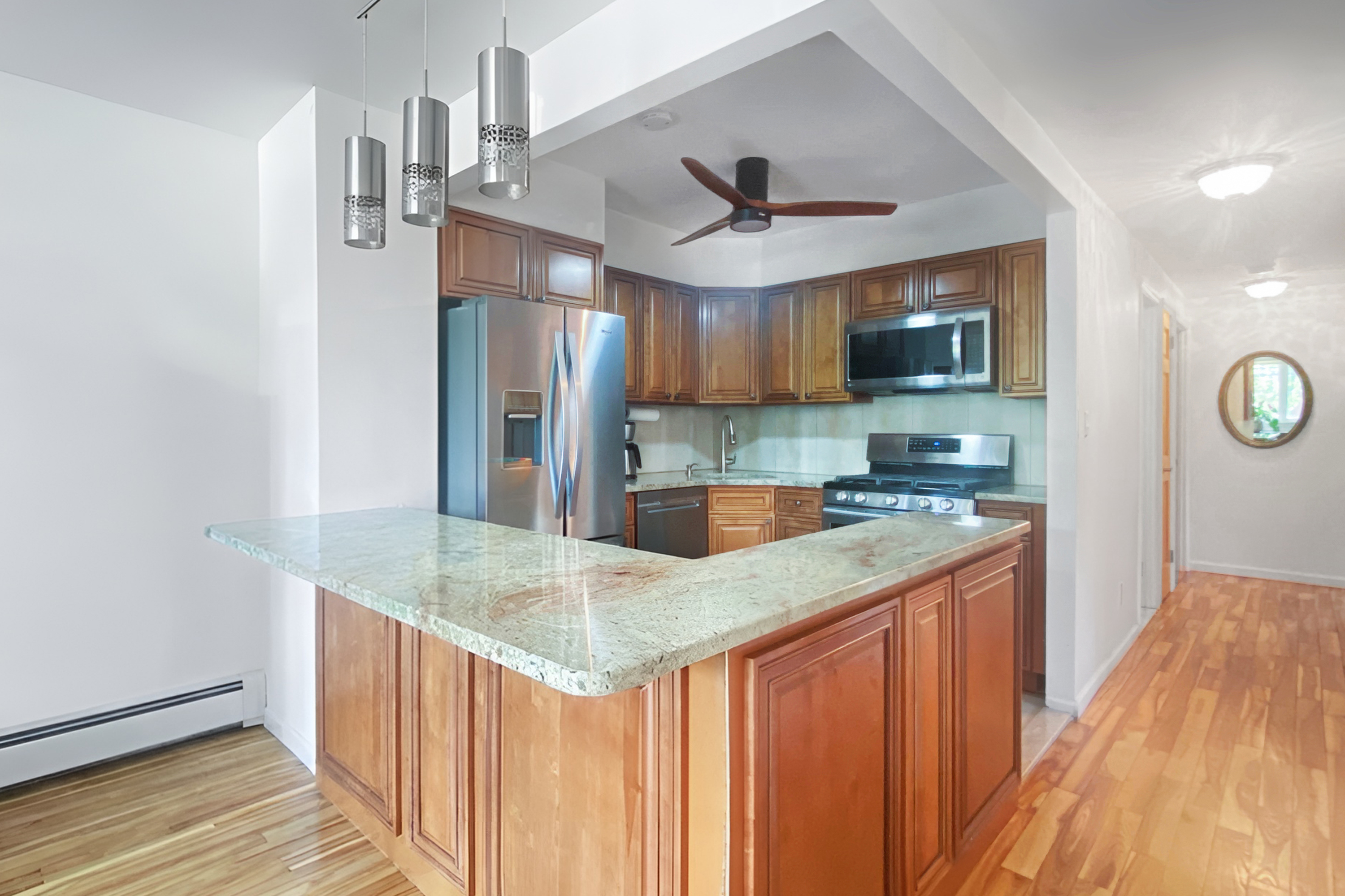 27-02 12th Street, Unit 1 Queens, NY 11102 - Photo 3 of 15 a kitchen with stainless steel appliances granite countertop a sink and a refrigerator