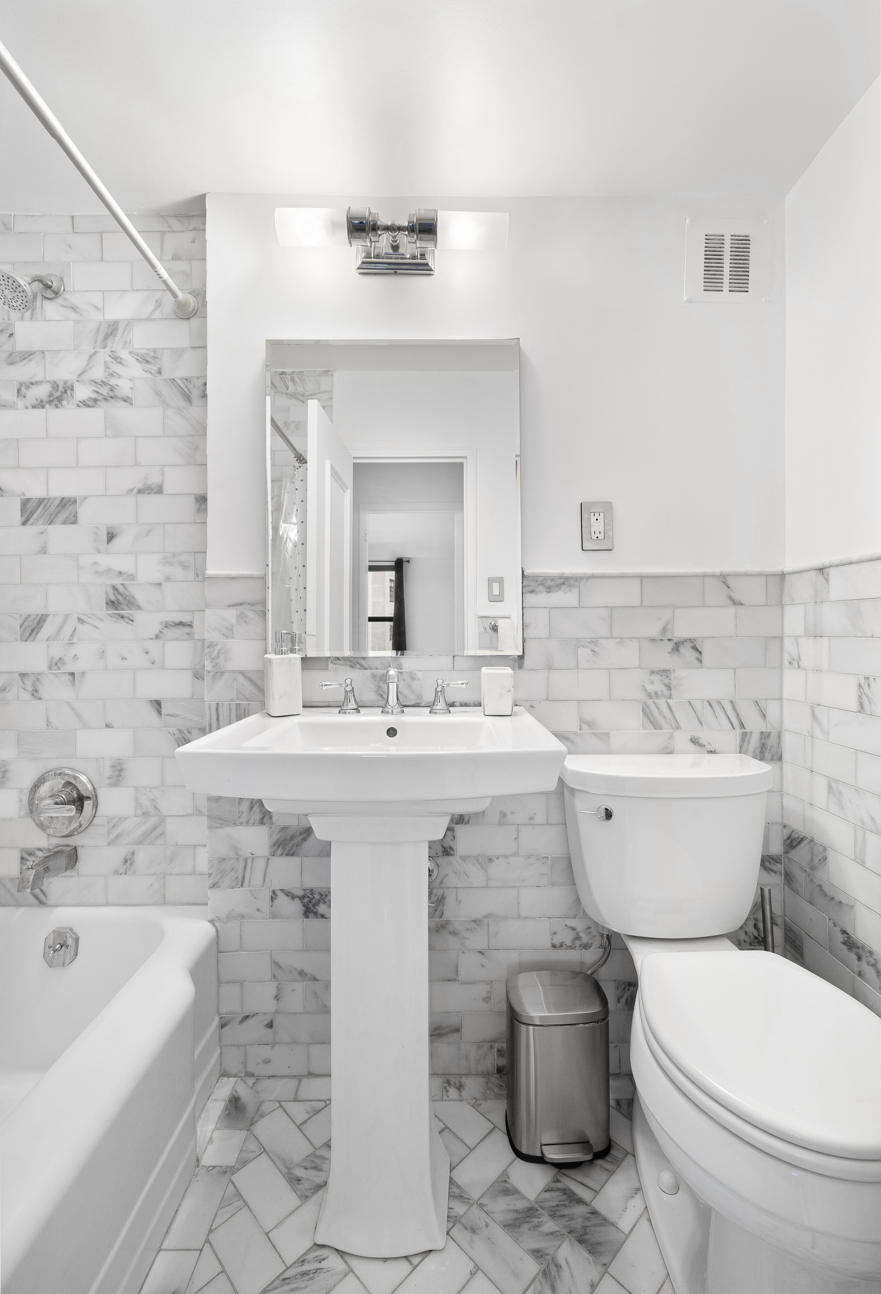 145 East 15th Street, Unit 7C Manhattan, NY 10003 - Photo 7 of 10 a bathroom with a sink toilet a mirror and bathtub