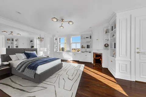 a spacious bedroom with a bed and a chandelier