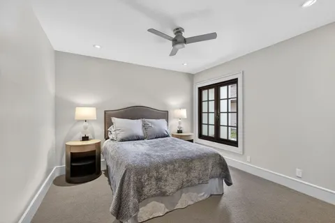 a bedroom with a bed and a ceiling fan