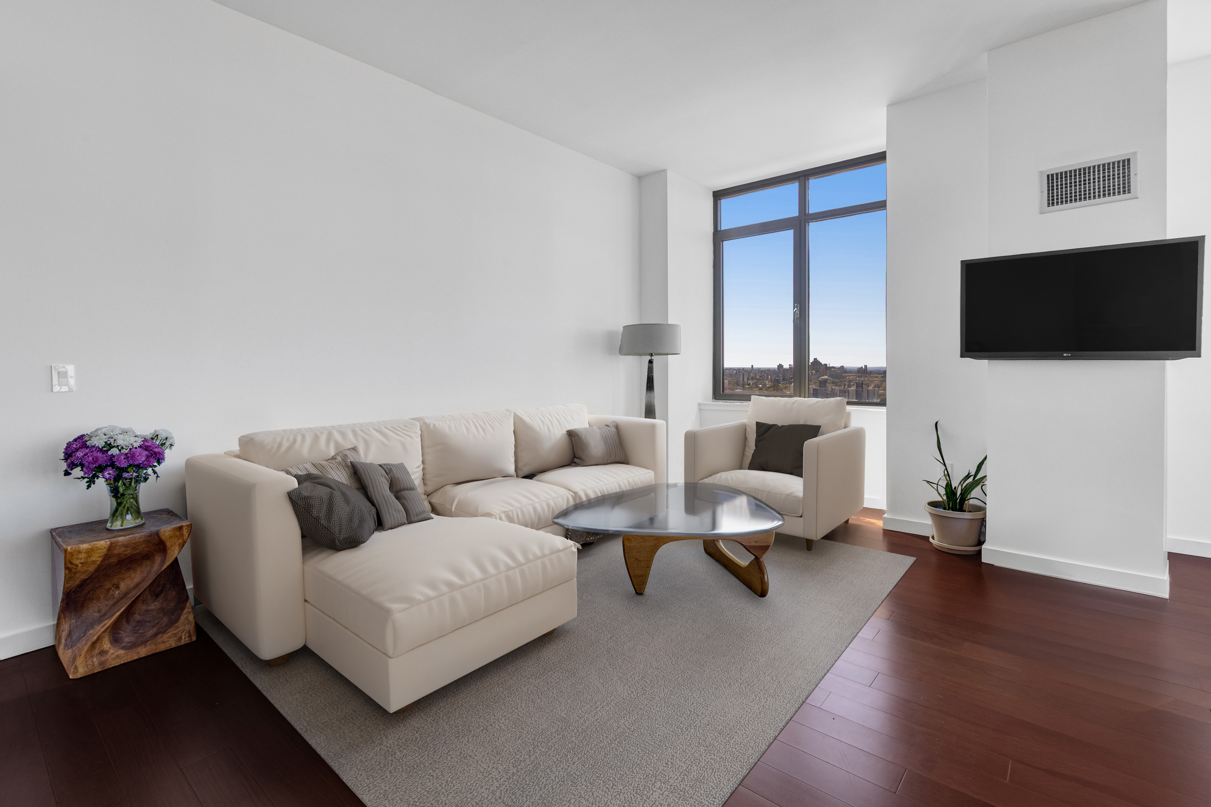1485 5th Avenue, Unit 24F Manhattan, NY 10035 - Photo 7 of 16 a living room with furniture and a flat screen tv