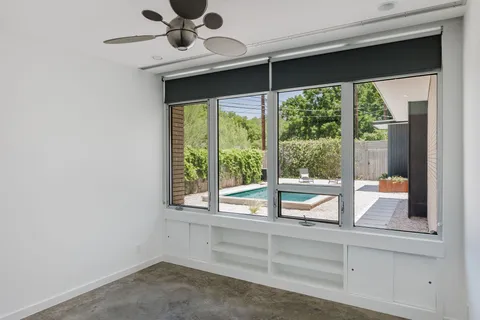 a view of a room that has a large window and furniture
