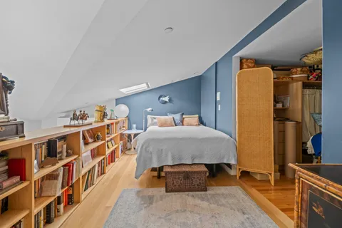 a bedroom with a bed and a book shelf