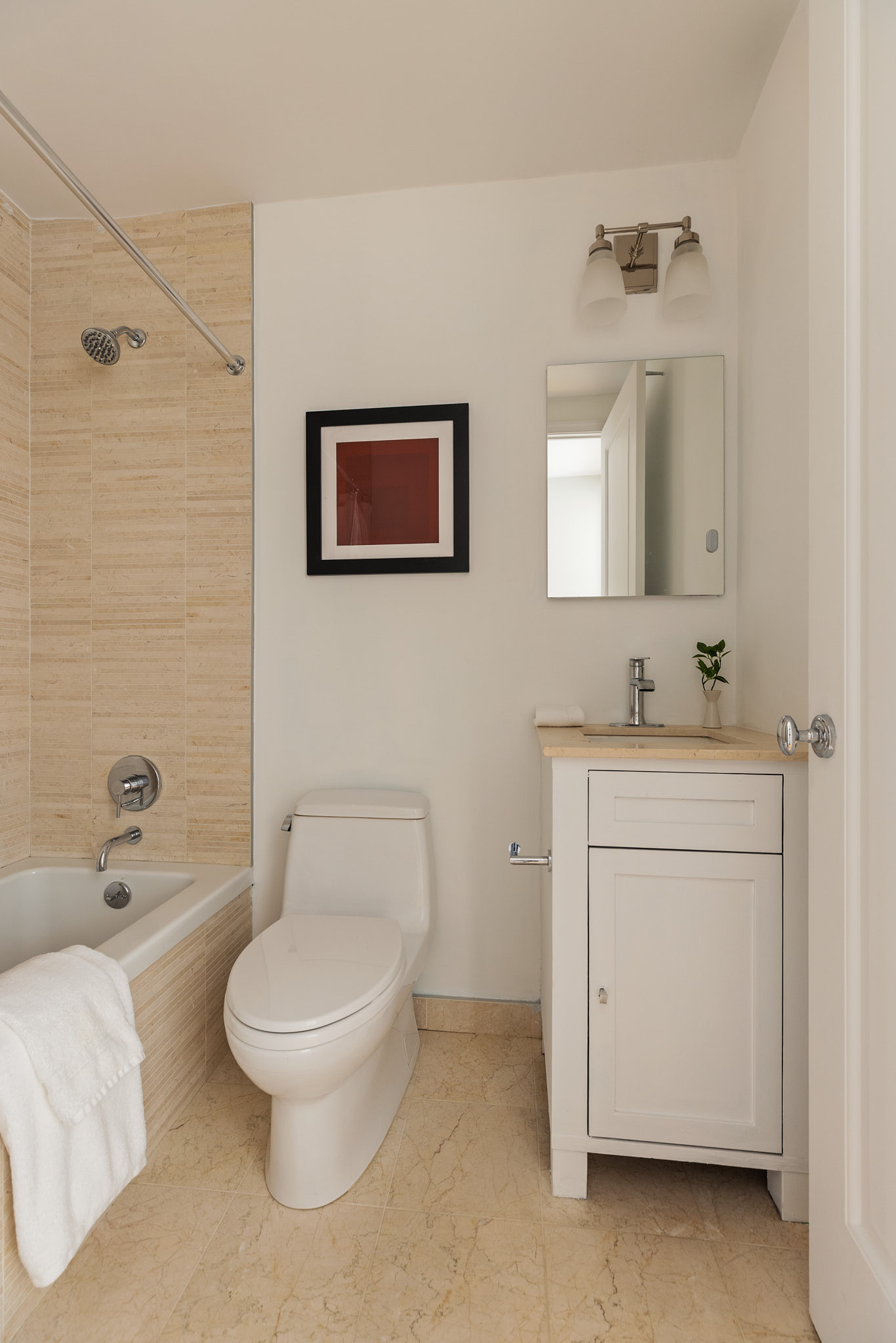 1438 3rd Avenue, Unit 15B Manhattan, NY 10028 - Photo 17 of 21 a bathroom with a toilet sink vanity tub and shower