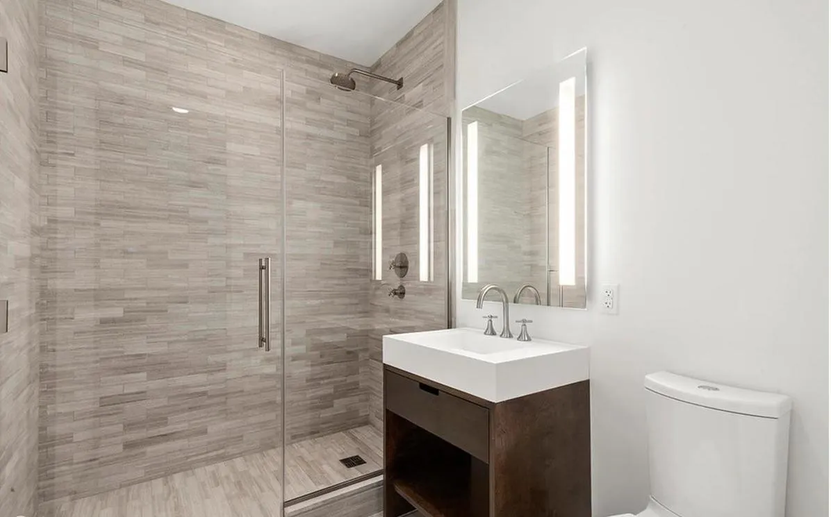250 West Street, Unit 3F Manhattan, NY 10013 - Photo 8 of 11 a bathroom with a sink mirror and shower