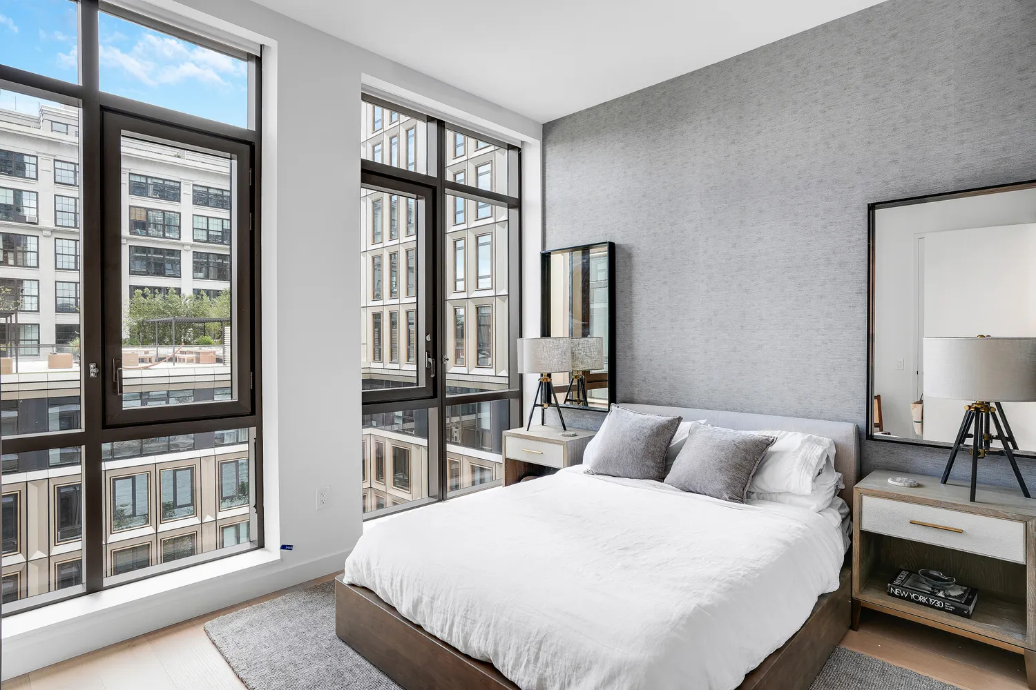 a bedroom with a bed and a large window with outer view