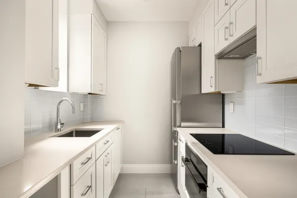 a kitchen with granite countertop a sink stove and refrigerator