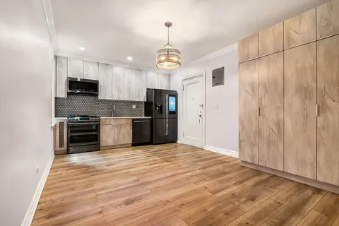 a view of kitchen with stainless steel appliances granite countertop a stove top oven a sink and a refrigerator