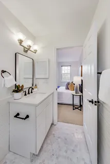 a bathroom with a double vanity sink mirror and tub