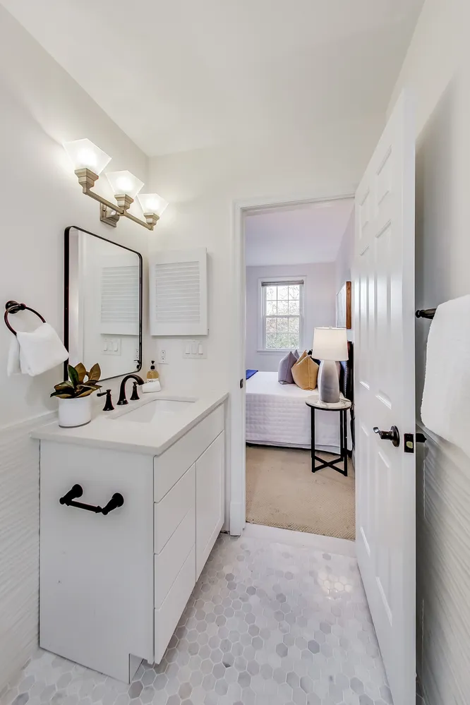a bathroom with a double vanity sink mirror and tub