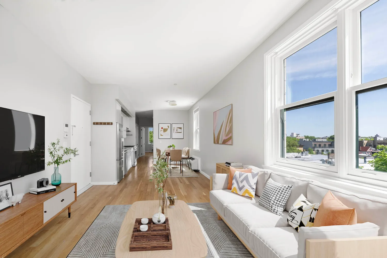 a view of a hallway with wooden floor and a bathroom