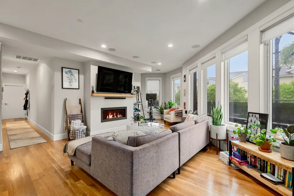 a living room with furniture a flat screen tv and a fireplace