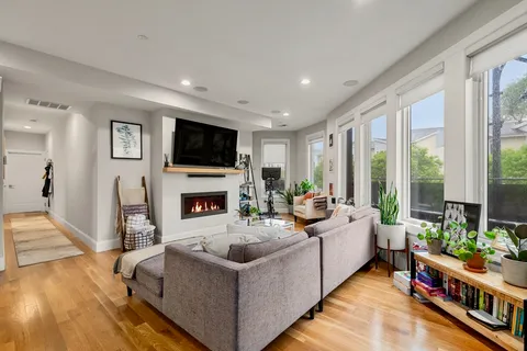 a living room with furniture a flat screen tv and a fireplace