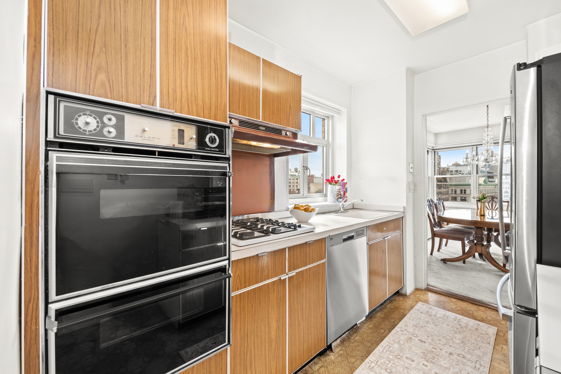 20 East 9th Street, Unit 18E Manhattan, NY 10003 - Photo 16 of 40 a kitchen with stainless steel appliances granite countertop a stove and a sink
