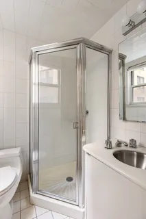 a bathroom with a shower a mirror and a sink