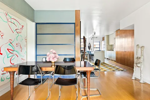 a living room with furniture and a painting on the wall