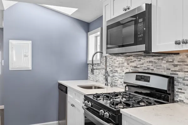 a kitchen with stainless steel appliances a stove a microwave sink and cabinets