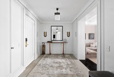 a view of a hallway view with wooden floor and a bathroom
