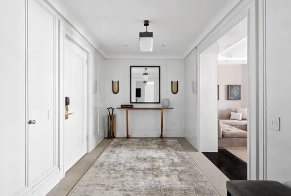 a view of a hallway view with wooden floor and a bathroom