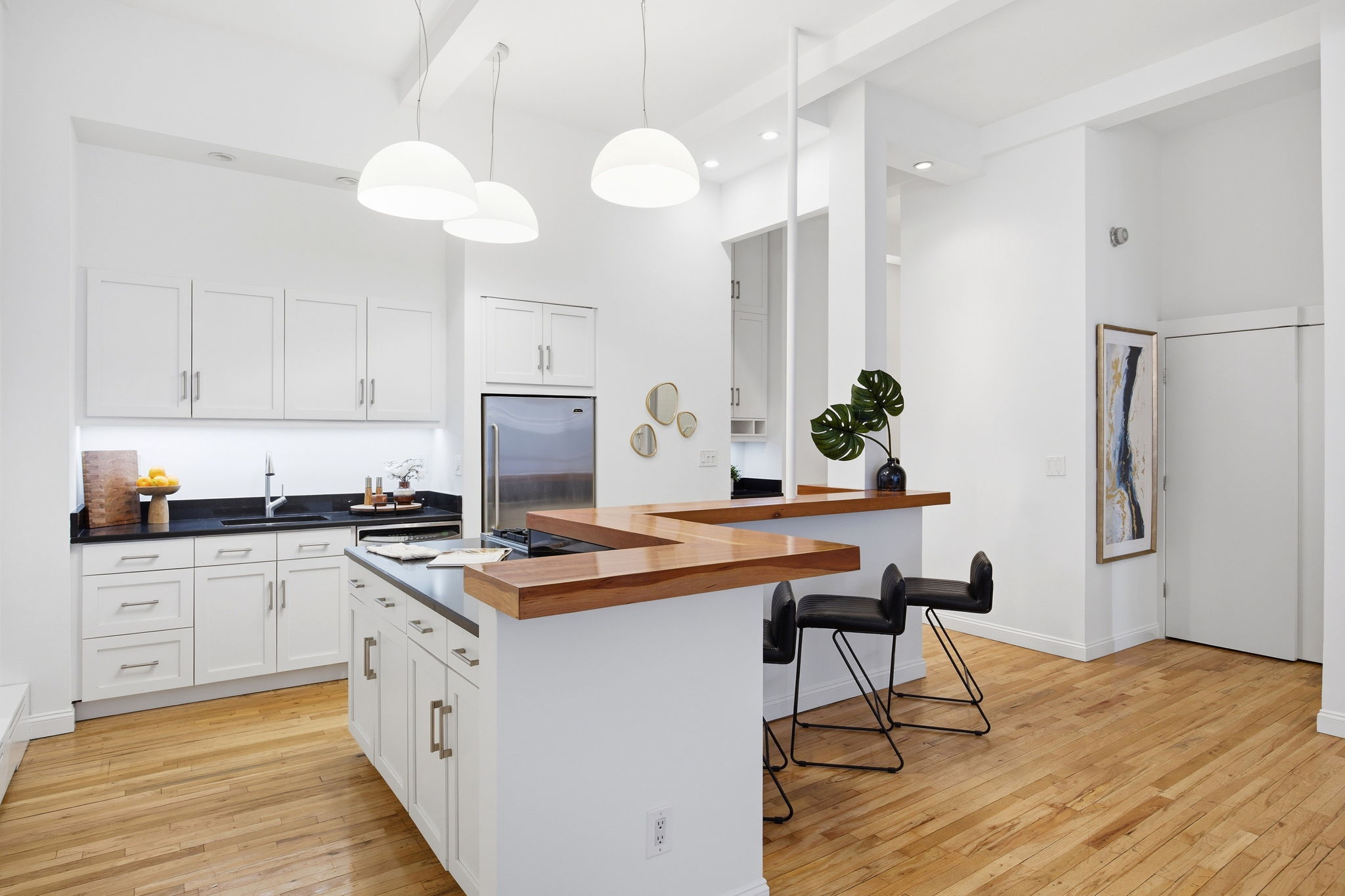 114 East 13th Street, Unit 6B Manhattan, NY 10003 - Photo 7 of 12 a kitchen with stainless steel appliances granite countertop a stove a sink dishwasher and white cabinets with wooden floor