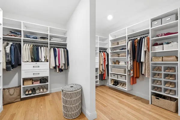 a view of walk in closet with clothes and shoes
