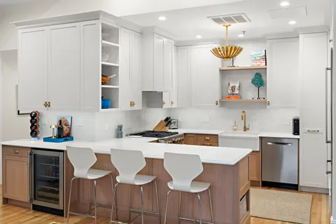 a kitchen with a sink a stove cabinets and chairs
