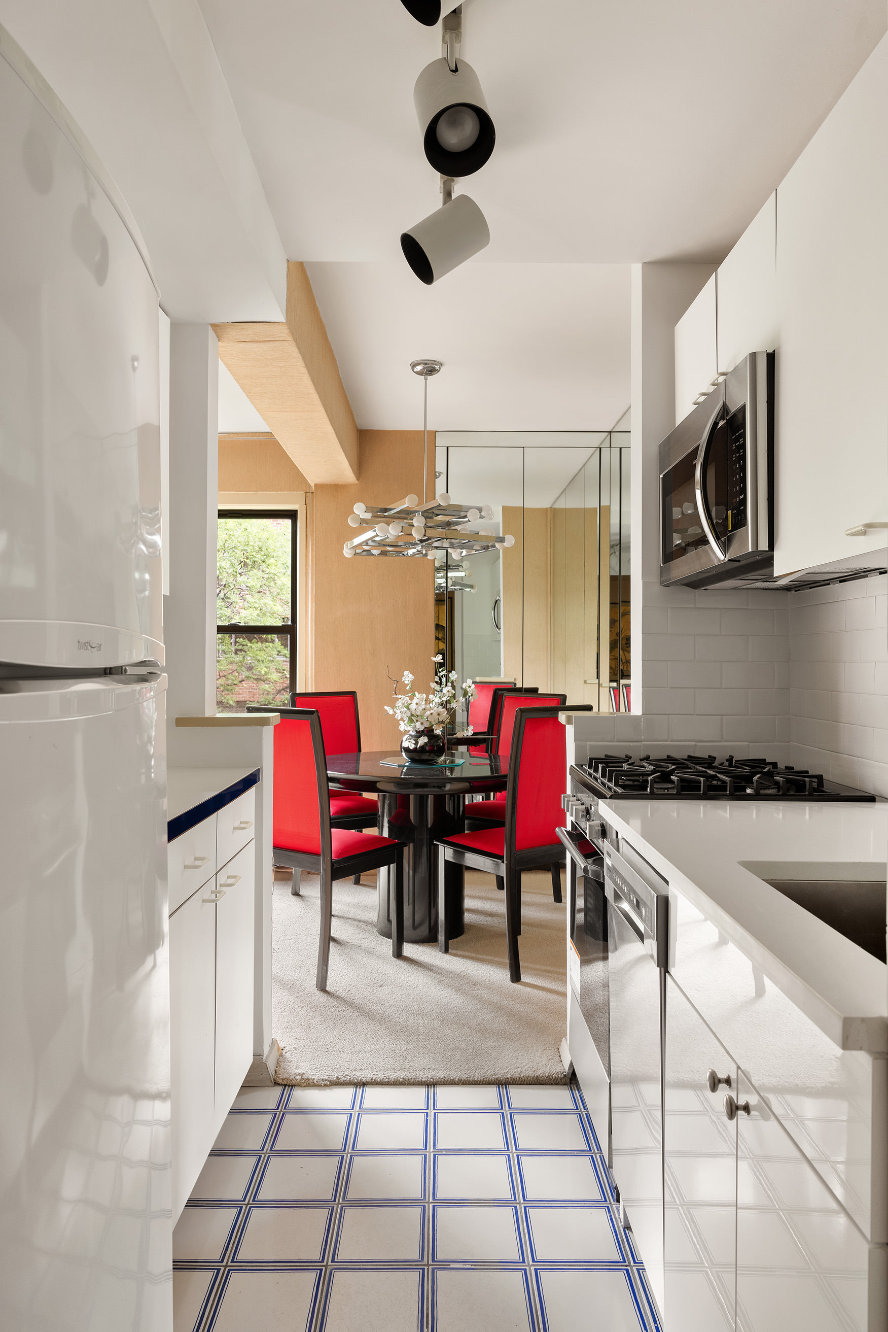 515 East 85th Street, Unit 6D Manhattan, NY 10028 - Photo 8 of 16 a kitchen with stainless steel appliances kitchen island granite countertop a stove a sink and a microwave