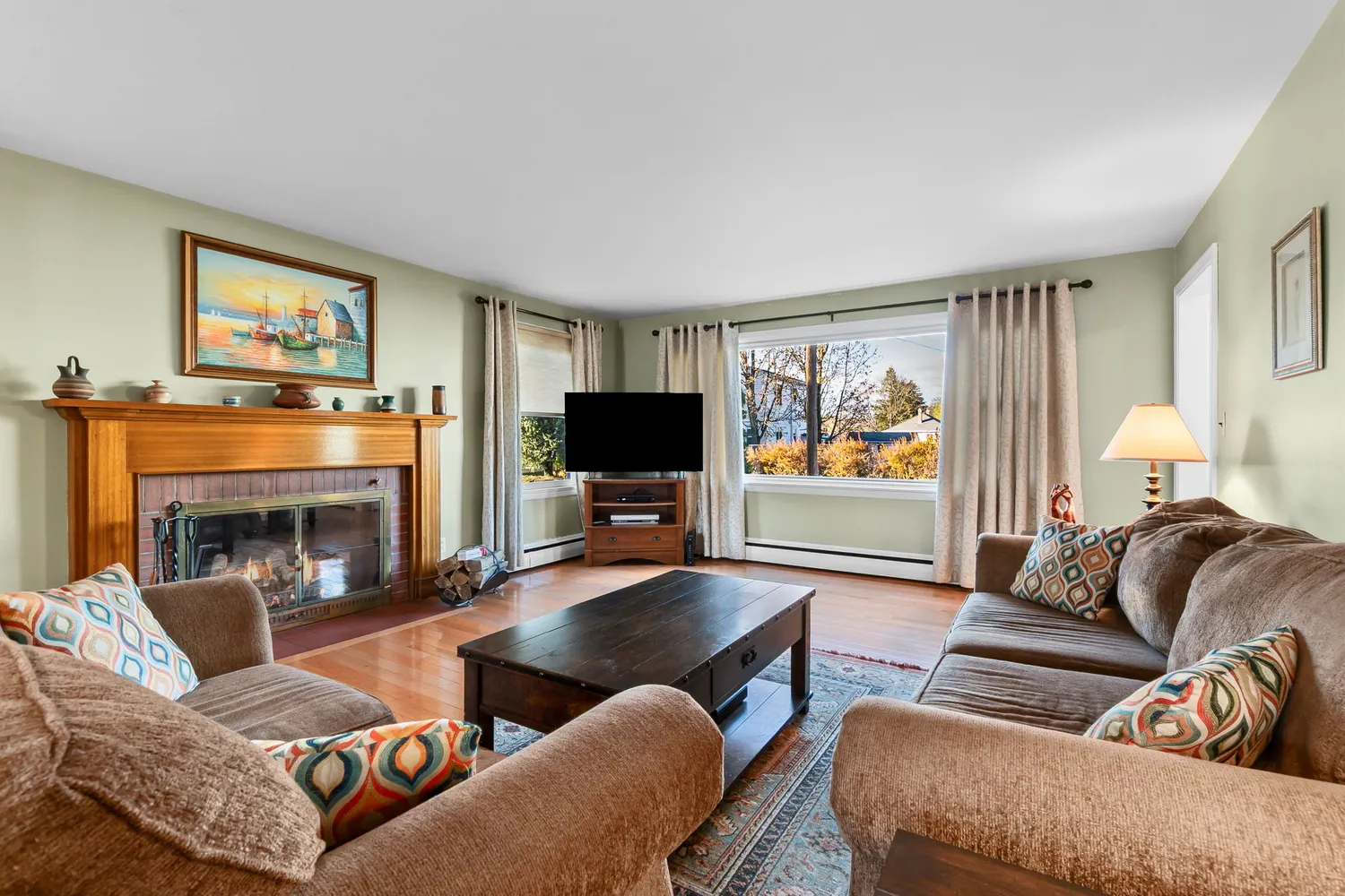 a living room with furniture a fireplace and a flat screen tv