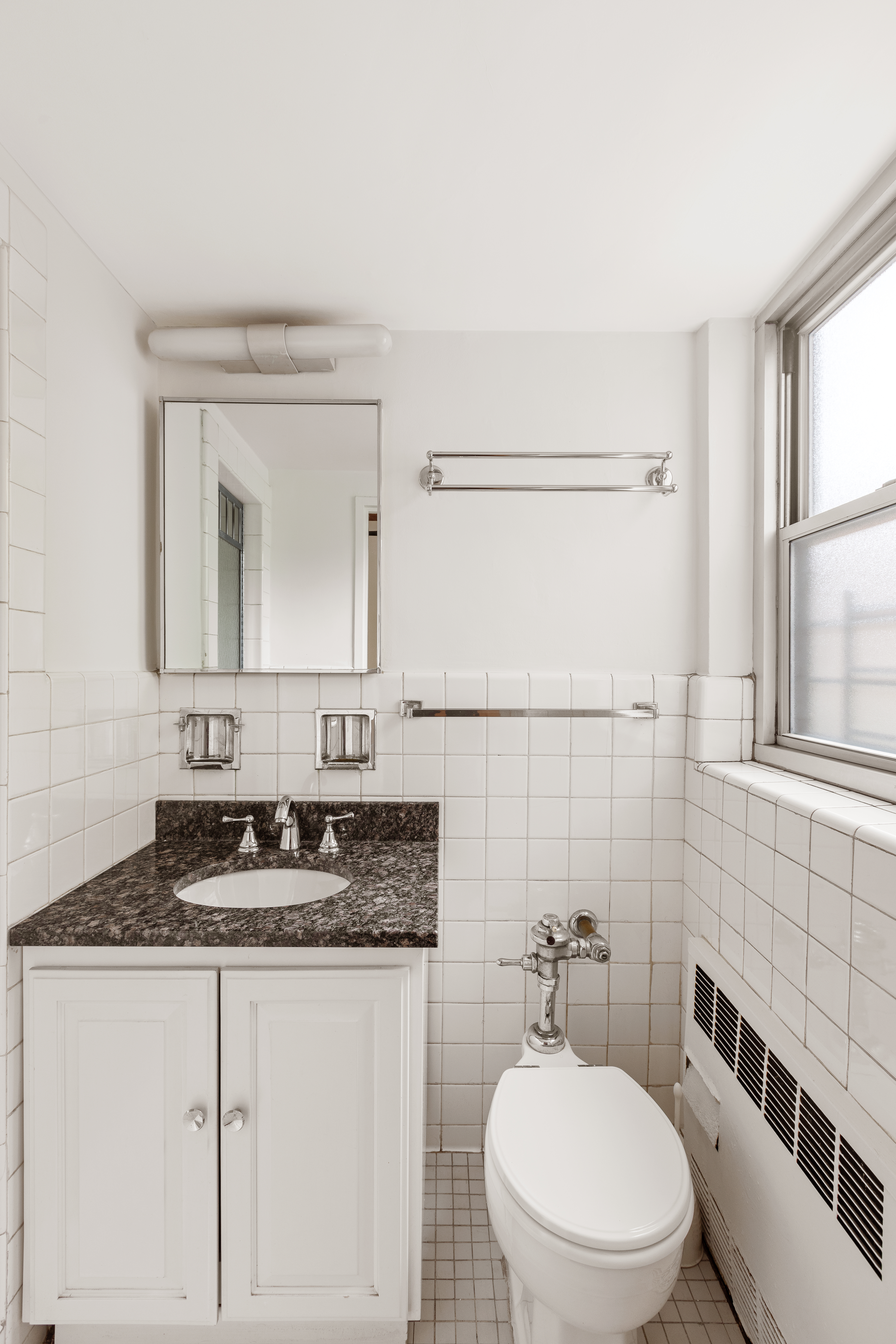 70 East 10th Street, Unit 3M Manhattan, NY 10003 - Photo 8 of 14 a bathroom with a granite countertop sink mirror and a toilet