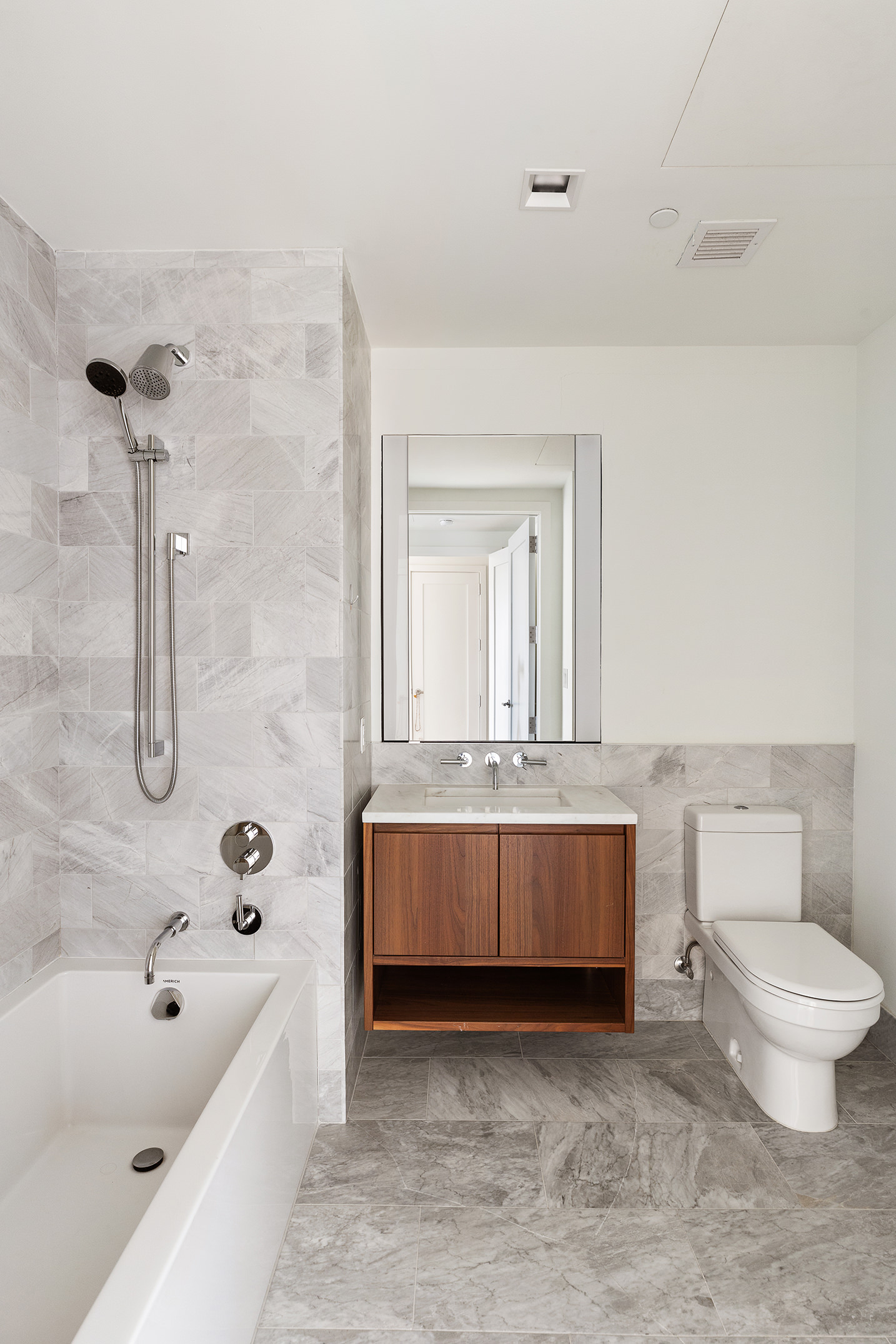 242 Broome Street, Unit 7C Manhattan, NY 10002 - Photo 6 of 7 a bathroom with a sink a toilet and bathtub