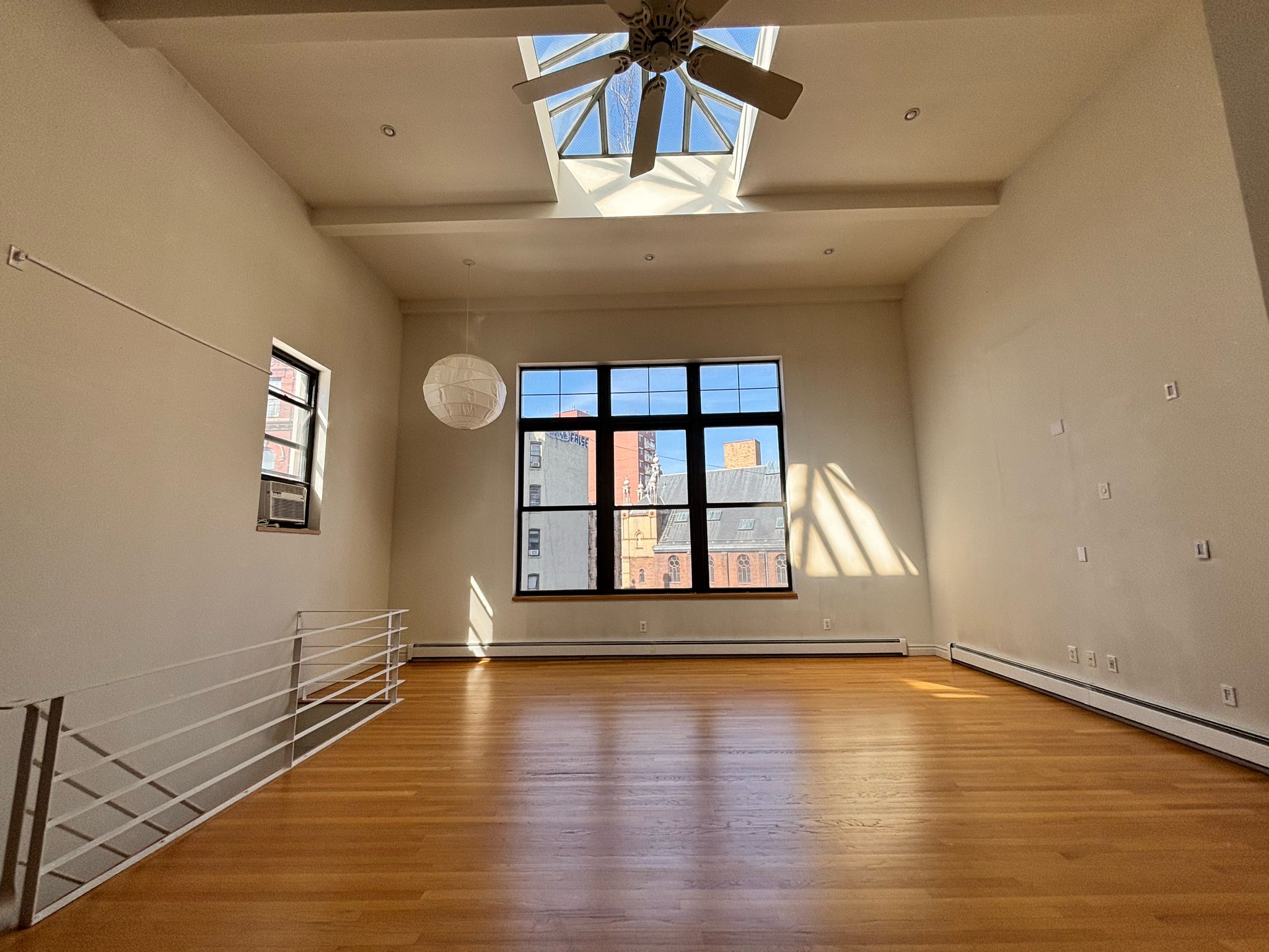 85 Division Street, Unit 4 Manhattan, NY 10002 - Photo 14 of 22 a view of an empty room with wooden floor and a window