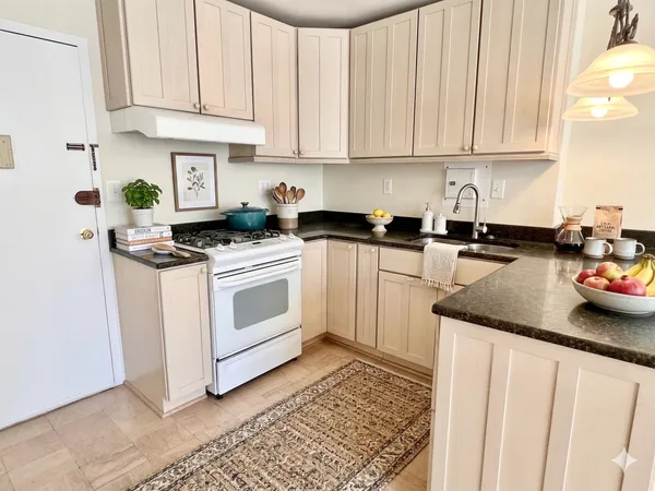 a kitchen with white cabinets and white appliances