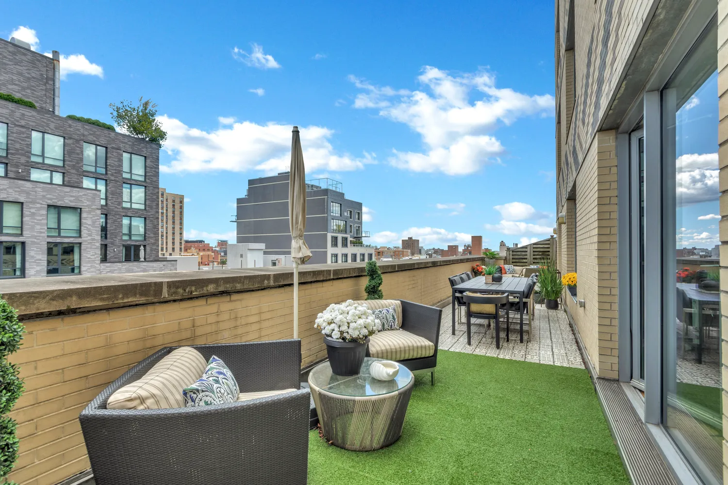 a view of a roof deck with couches and potted plants