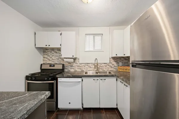 a kitchen with stainless steel appliances granite countertop a stove a sink and a refrigerator