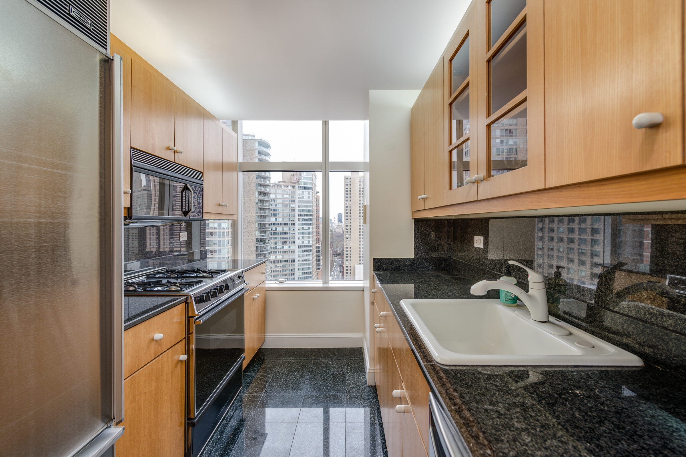 160 West 66th Street, Unit 23D Manhattan, NY 10023 - Photo 3 of 10 a kitchen with stainless steel appliances granite countertop a stove and a sink