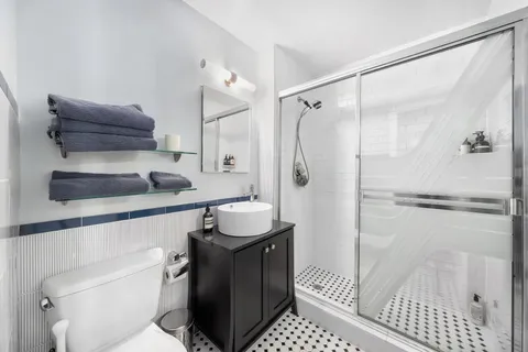 a bathroom with a sink a toilet and shower