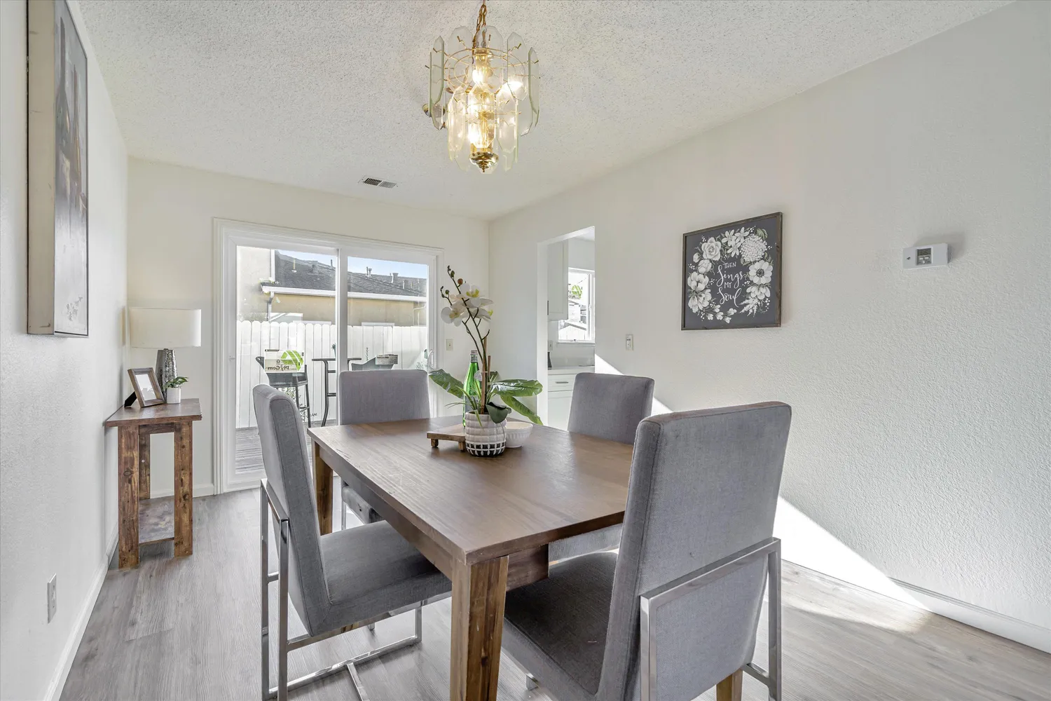 a view of a dining room with furniture a chandelier and wooden floor