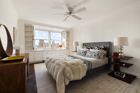 a bedroom with a bed and a flat tv screen on the dresser