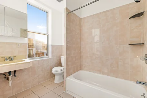 a white bath tub sitting next to a white toilet and a sink