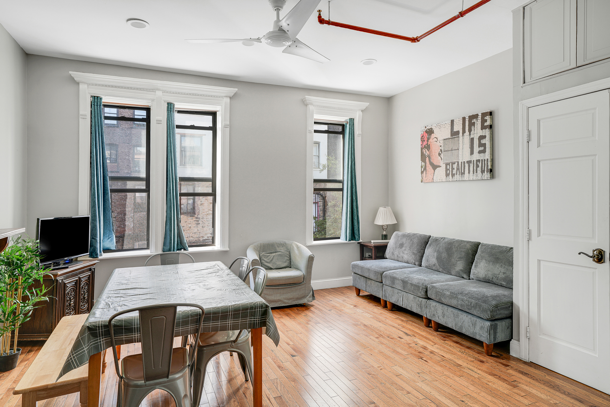 205 Edgecombe Avenue Manhattan, NY 10030 - Photo 14 of 21 a living room with furniture a flat screen tv and a window