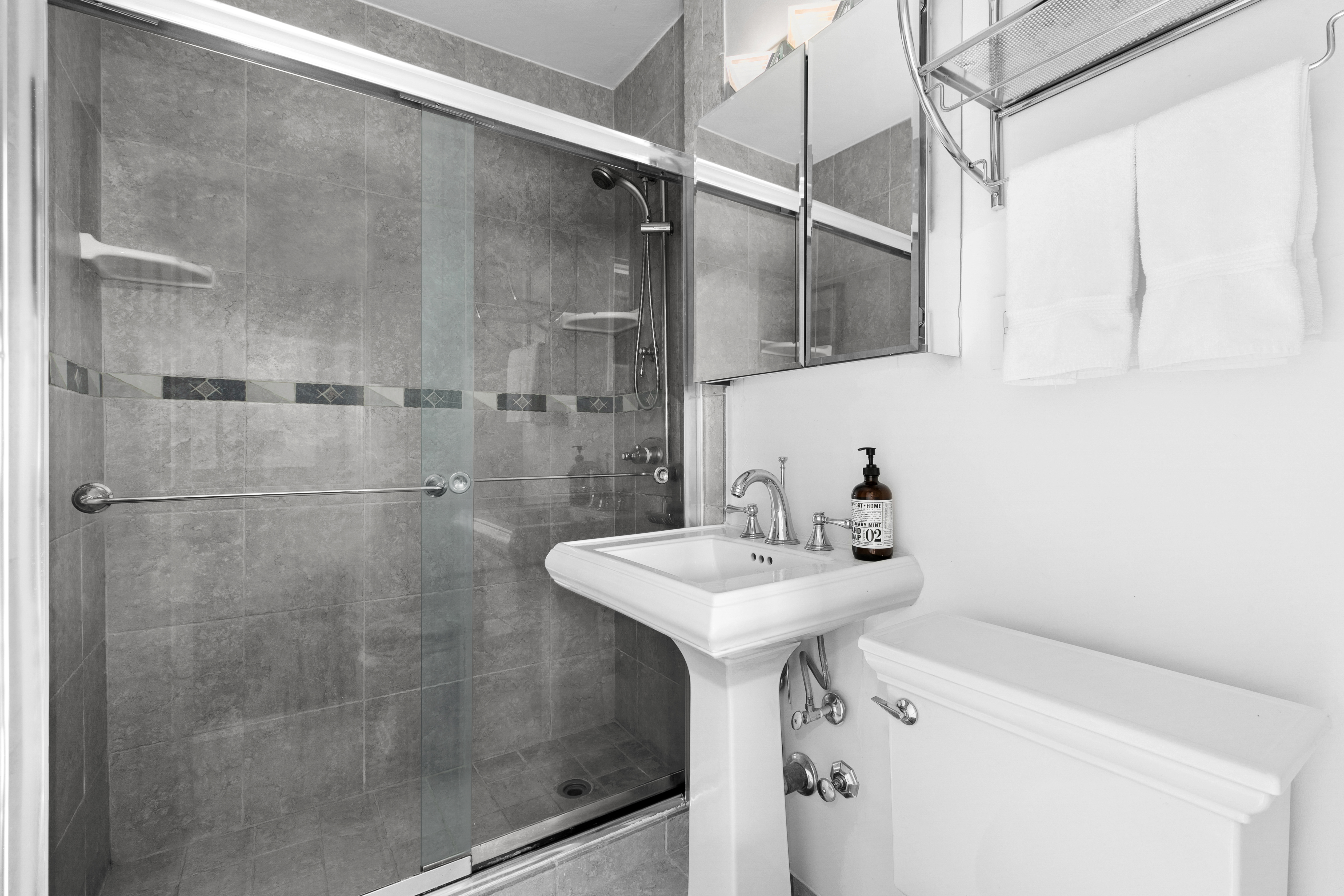 201 West 21st Street, Unit 8G Manhattan, NY 10011 - Photo 6 of 8 a bathroom with a sink mirror and shower