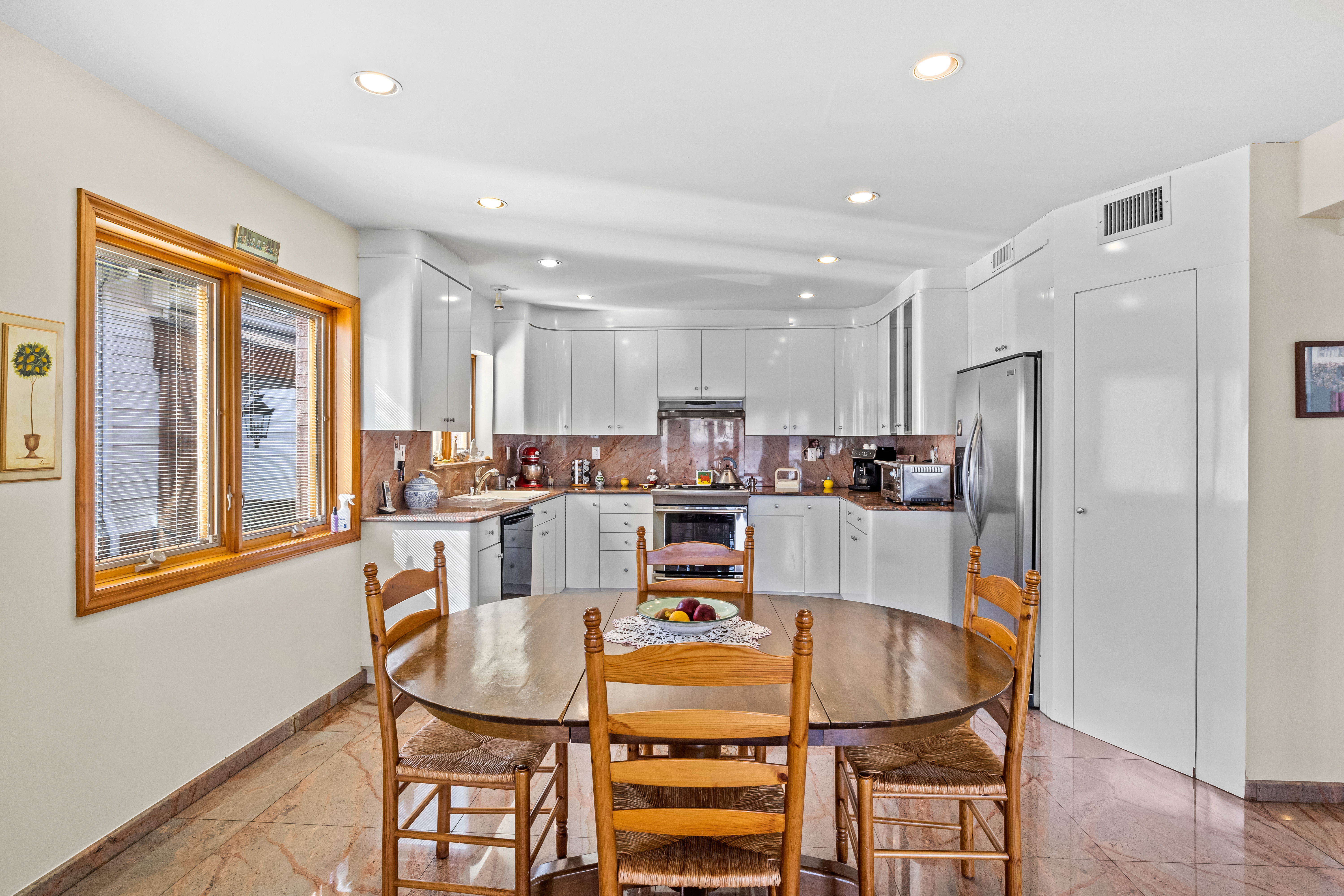 303 Whitman Drive Brooklyn, NY 11234 - Photo 13 of 37 a dining room with furniture a large window and kitchen view