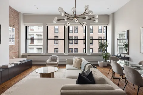 a living room with furniture kitchen view and large windows