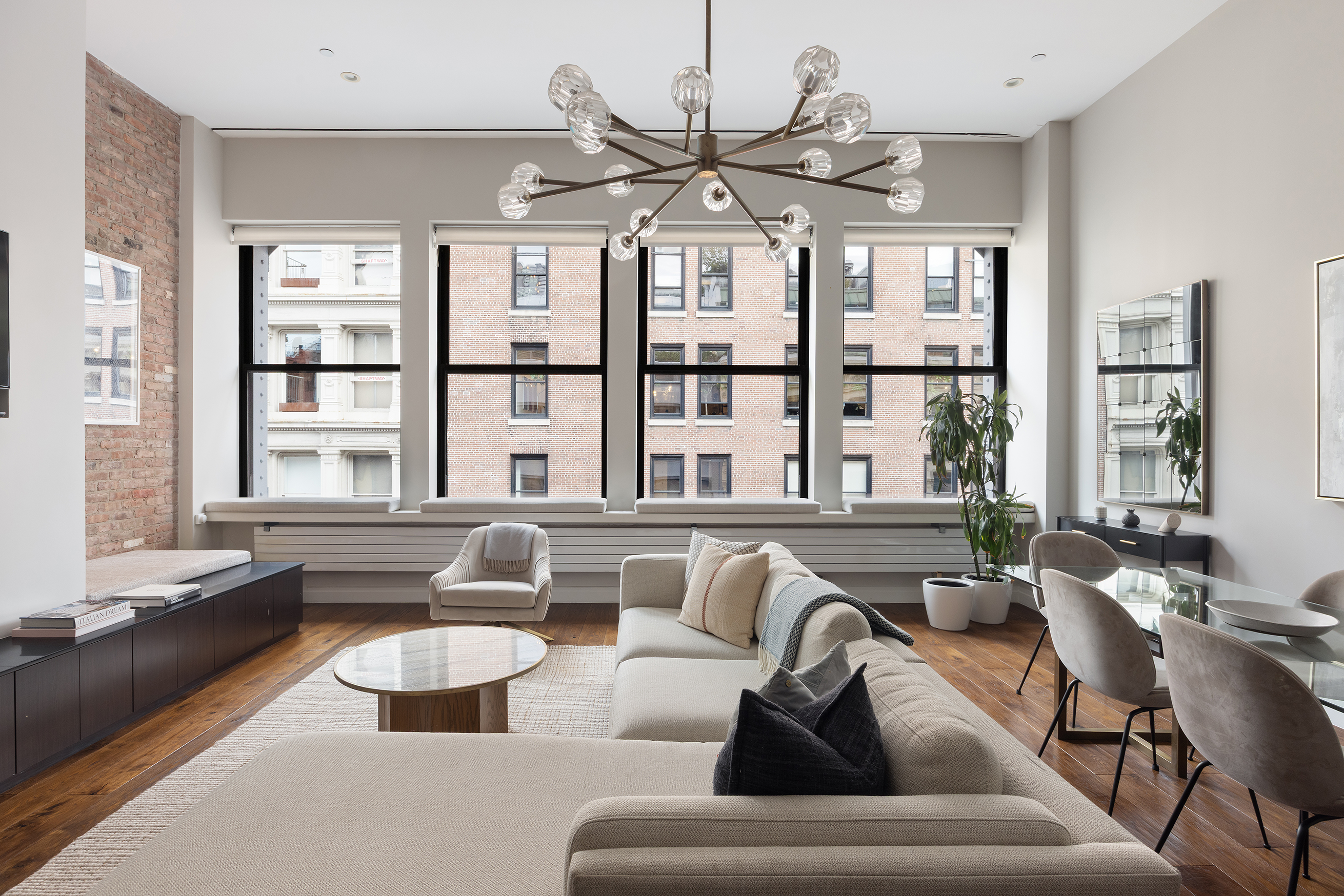 109 Greene Street, Unit 5A Manhattan, NY 10012 - Photo 3 of 18 a living room with furniture kitchen view and large windows