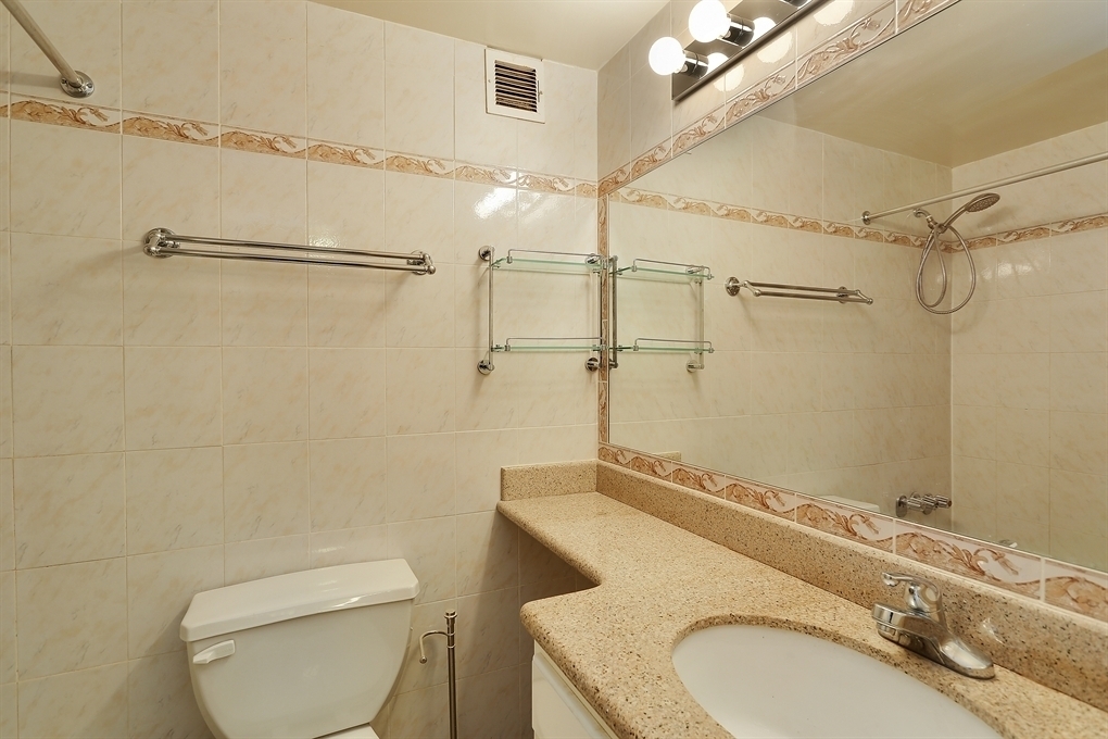 229 East 24th Street, Unit 9R Manhattan, NY 10010 - Photo 4 of 5 a bathroom with a granite countertop sink toilet and shower